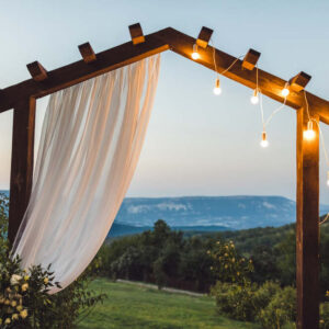 An outdoor wedding arch covered in lights frames a view of the Blue Ridge Mountains 